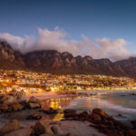 Beautiful illuminated Camps Bay, Scenic view after sunset with beautiful cloudscape. Camps Bay, famous suburb of the city of Cape Town with white sandy beaches underneath the Table Mountain. Cape Town, South Africa